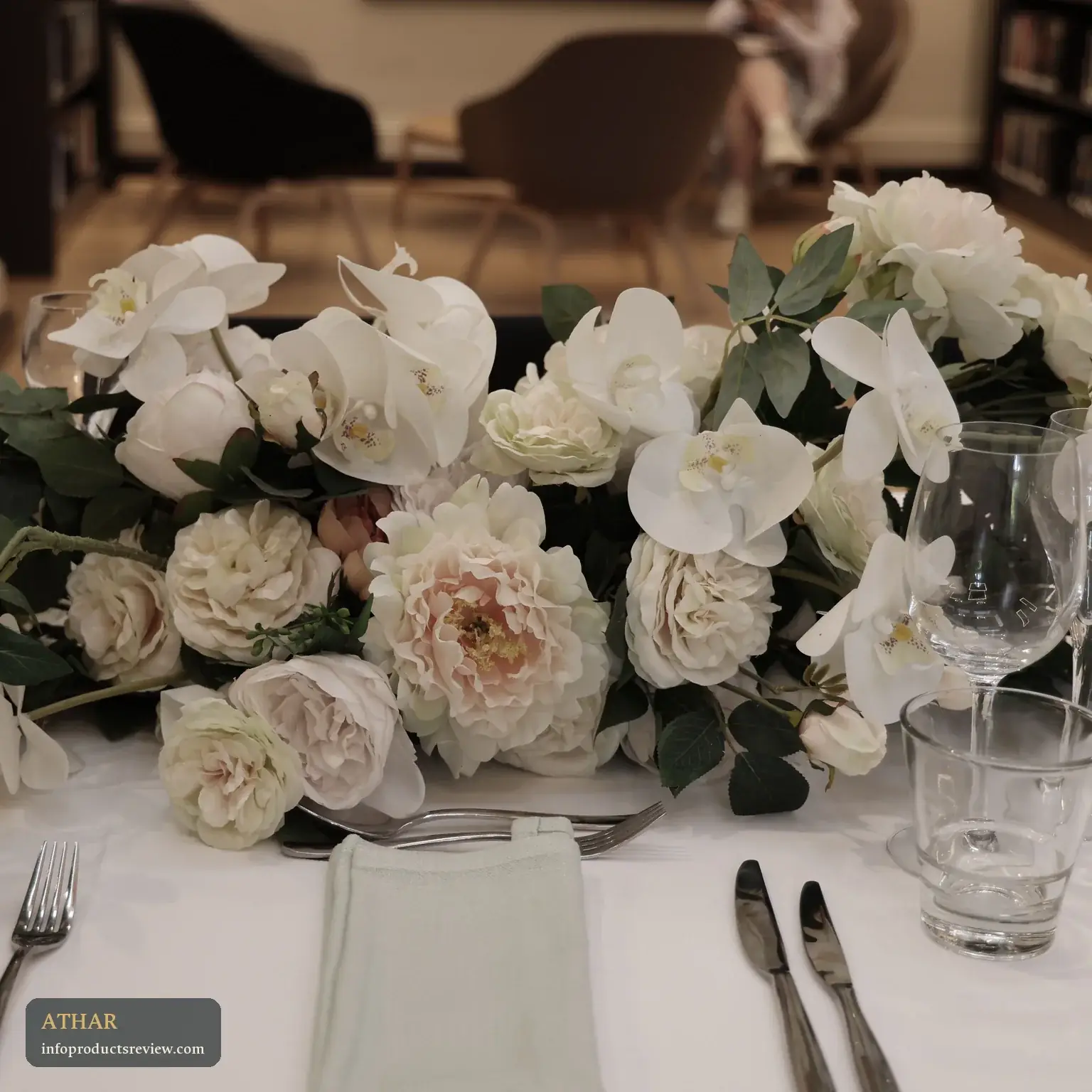 A table decorated with white flowers and tableware, set for an occasion